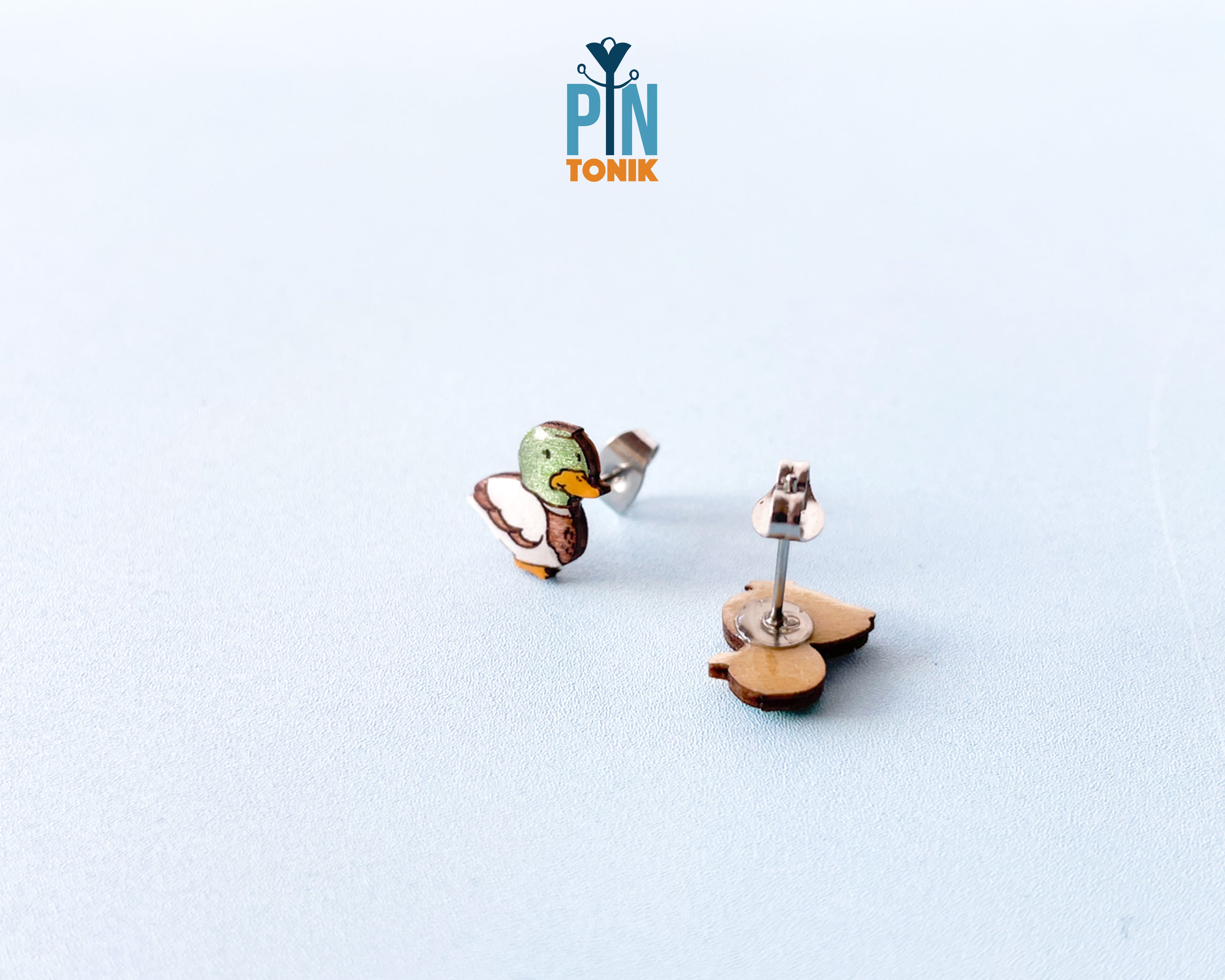 Pair of hand-painted wooden mallard duck stud earrings featuring a green head and brown body with a glossy resin finish