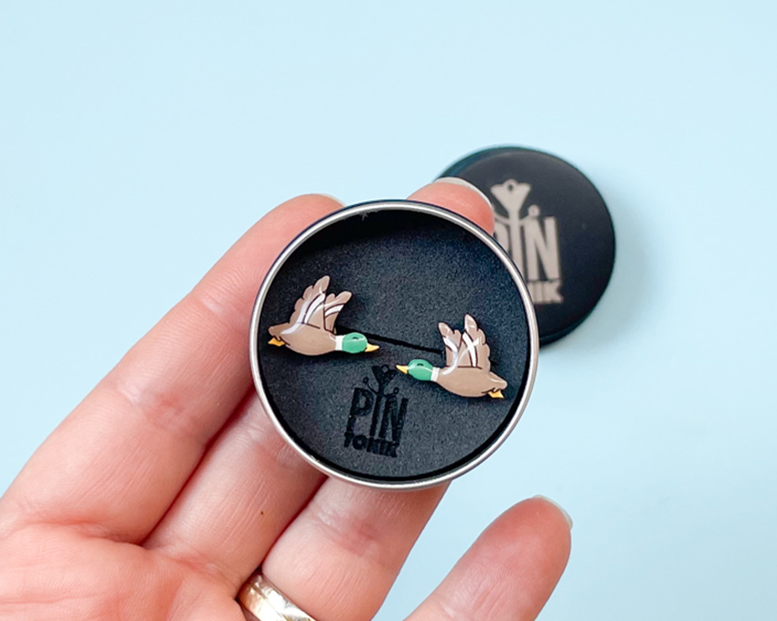 Pair of hand-painted wooden flying mallard duck stud earrings with wings spread and a glossy resin finish