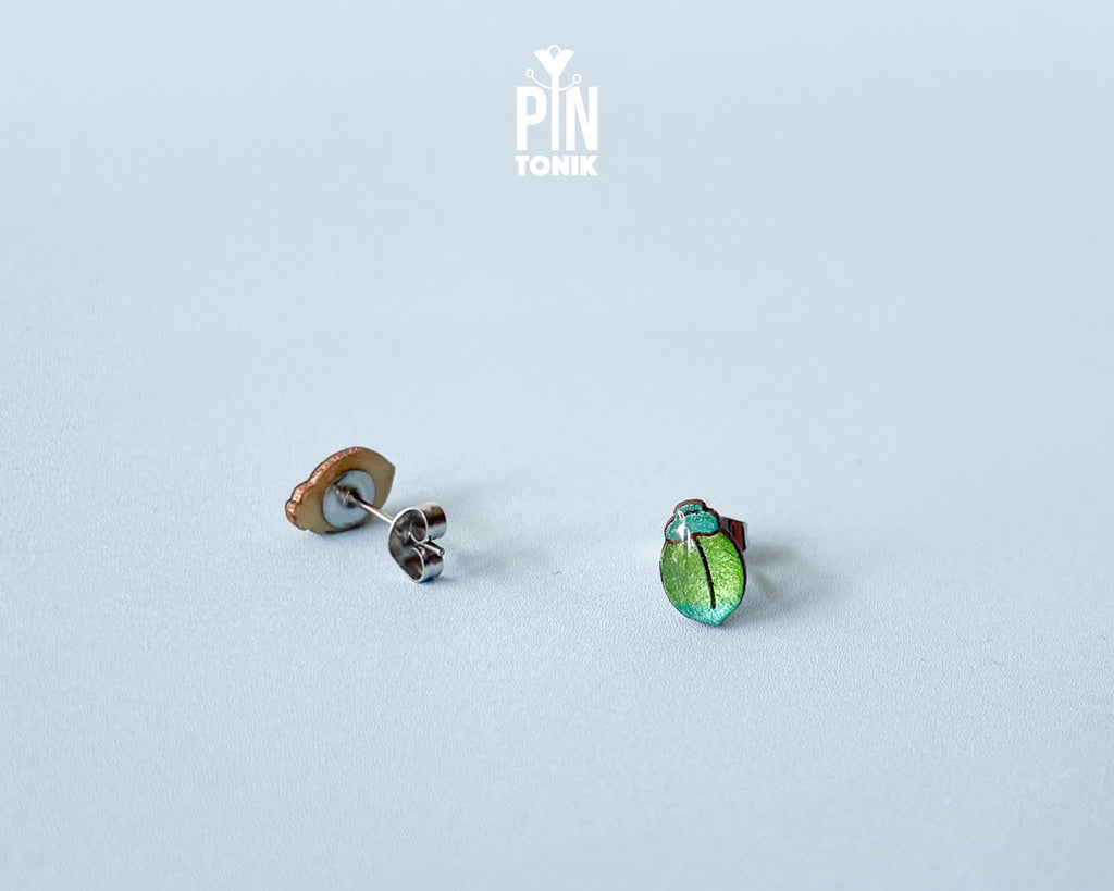 Handmade wooden milkweed beetle stud earrings with a shimmering iridescent green and blue finish by PinTonik.