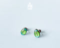 Handmade wooden milkweed beetle stud earrings with a shimmering iridescent green and blue finish by PinTonik.