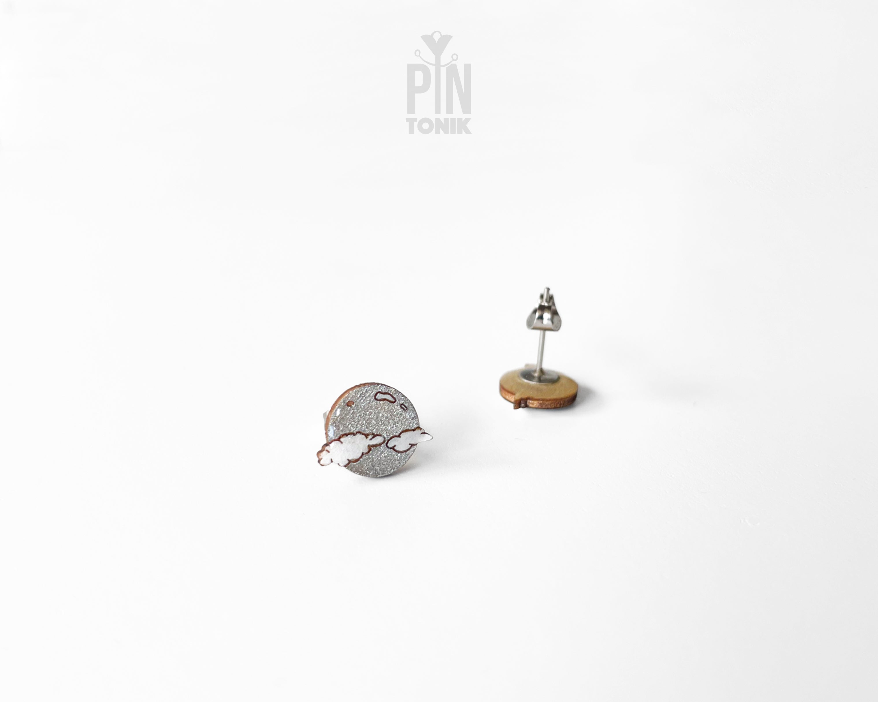 Handmade wooden celestial stud earrings featuring a silver glitter crescent moon behind a white cloud by PinTonik.