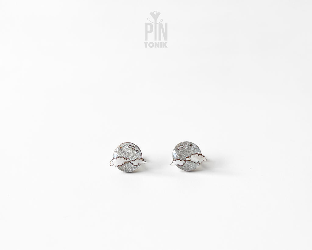 Handmade wooden celestial stud earrings featuring a silver glitter crescent moon behind a white cloud by PinTonik.
