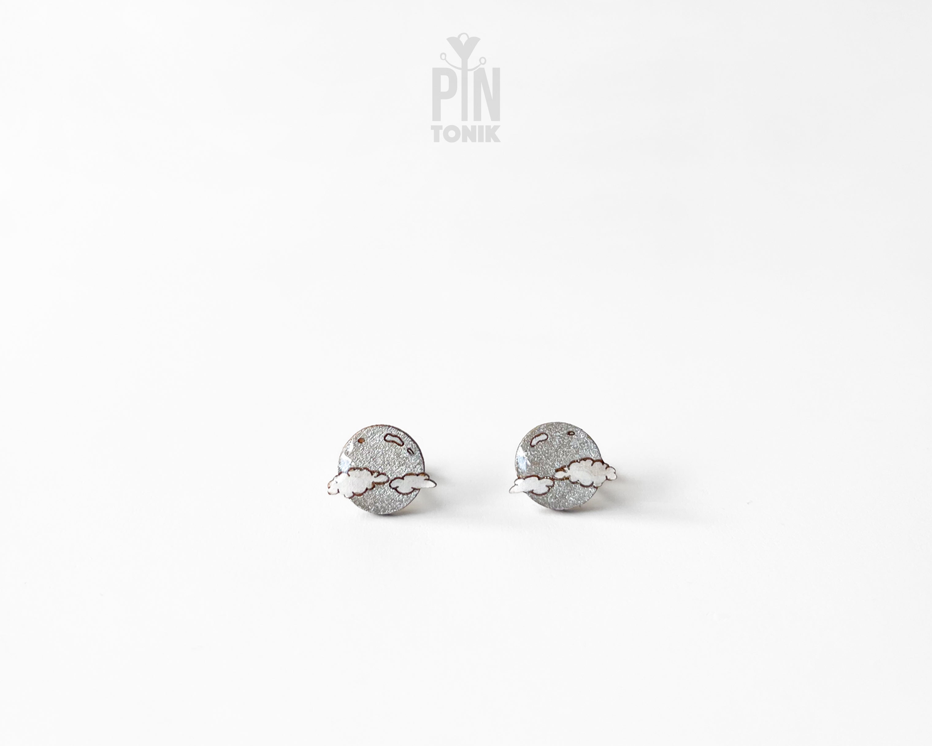 Handmade wooden celestial stud earrings featuring a silver glitter crescent moon behind a white cloud by PinTonik.
