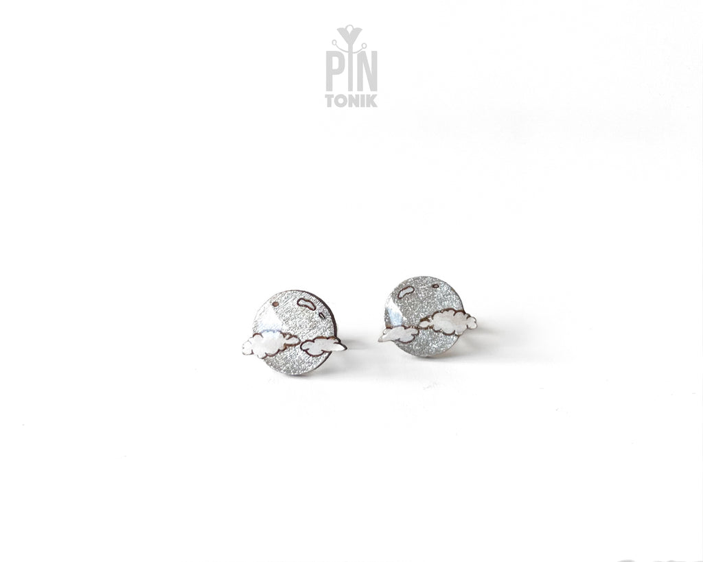 Handmade wooden celestial stud earrings featuring a silver glitter crescent moon behind a white cloud by PinTonik.