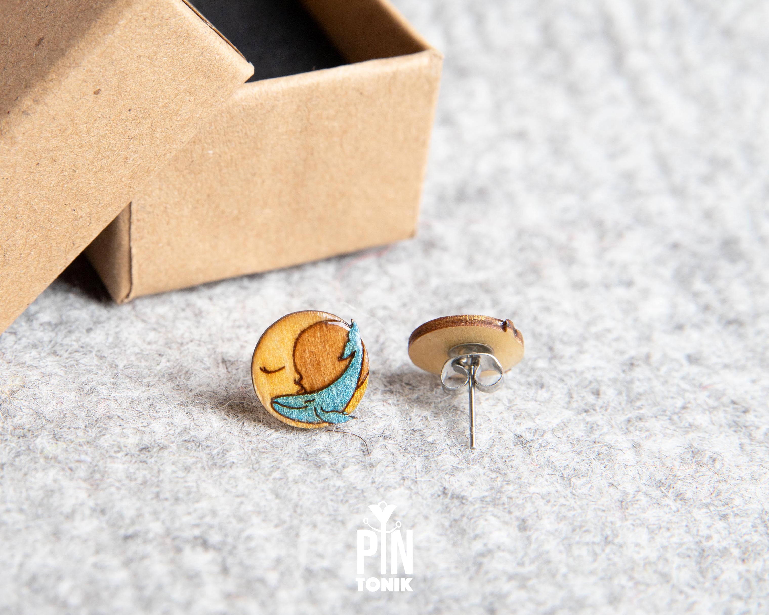 Handmade wooden stud earrings featuring a little blue whale sleeping inside a yellow crescent moon by PinTonik.