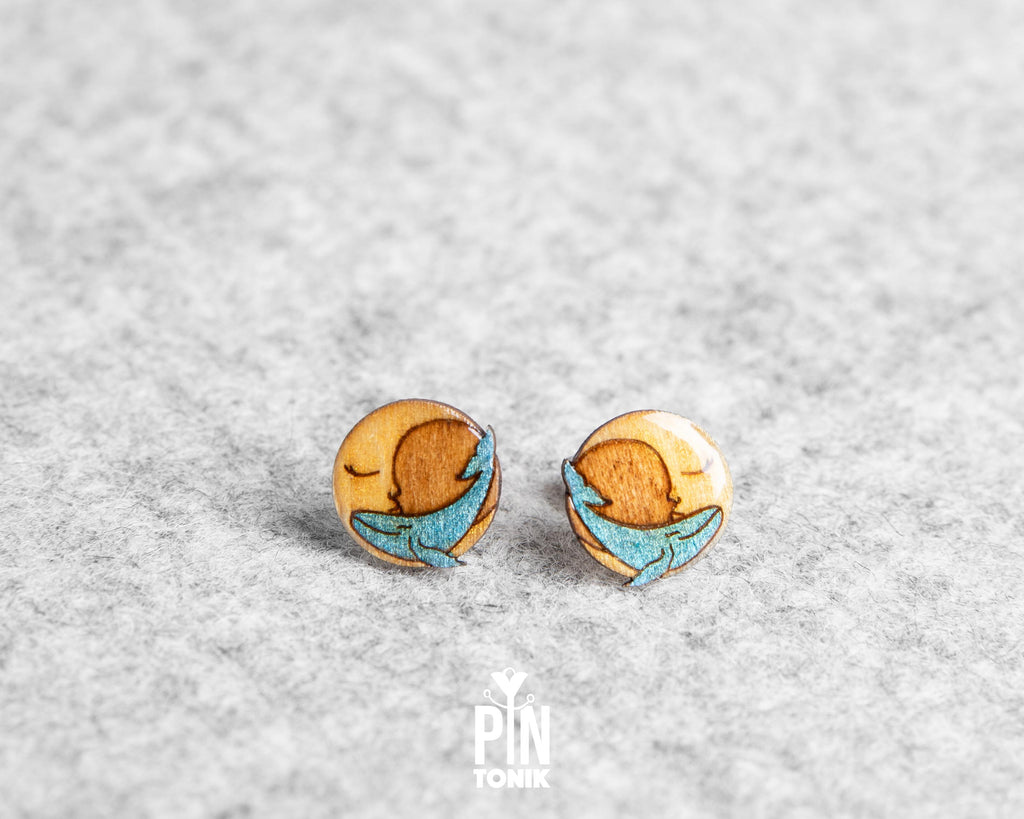 Handmade wooden stud earrings featuring a little blue whale sleeping inside a yellow crescent moon by PinTonik.