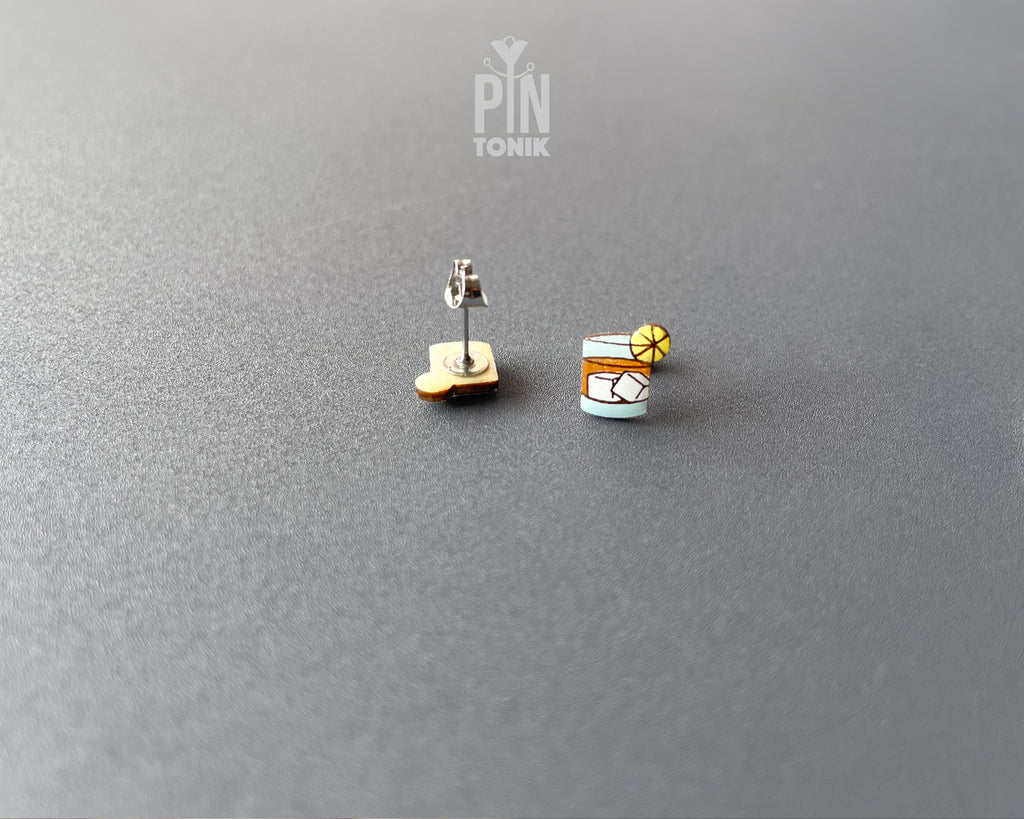 Handmade wooden cocktail tumbler stud earrings with a blue drink, ice cubes, and an orange wheel garnish by PinTonik.