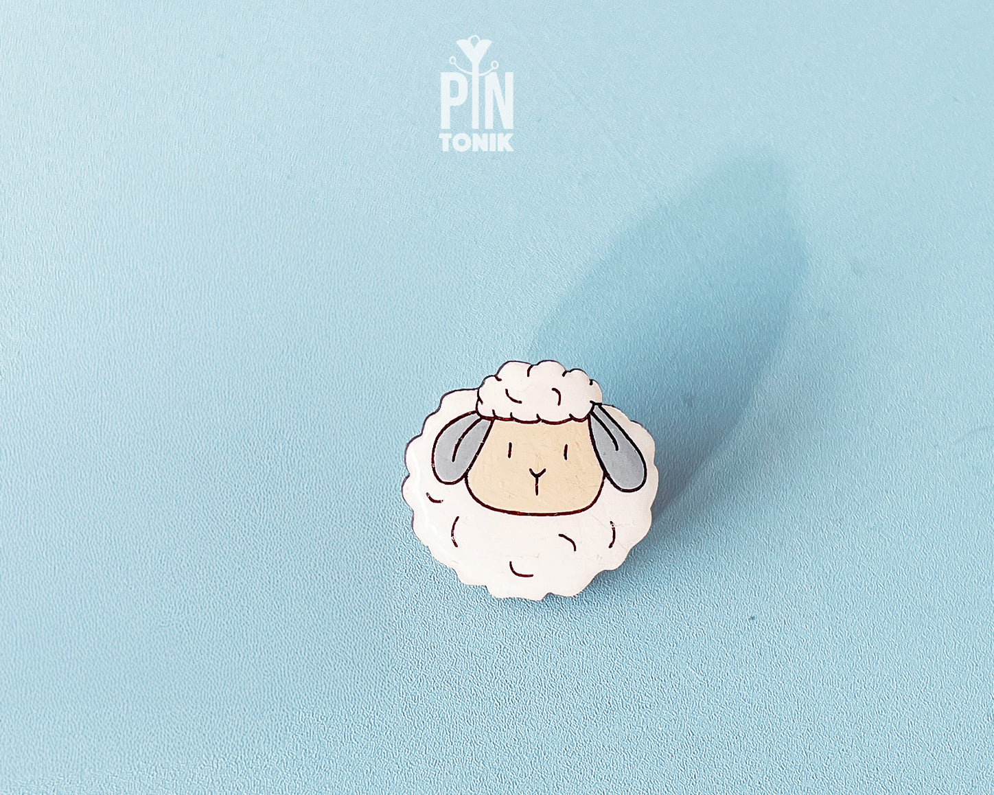 Hand-painted wooden sheep pin with a fluffy white wool design and a high-gloss resin finish
