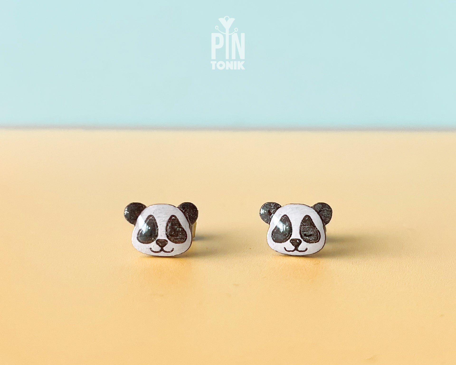 Pair of hand-painted wooden panda face stud earrings with a high-gloss resin finish