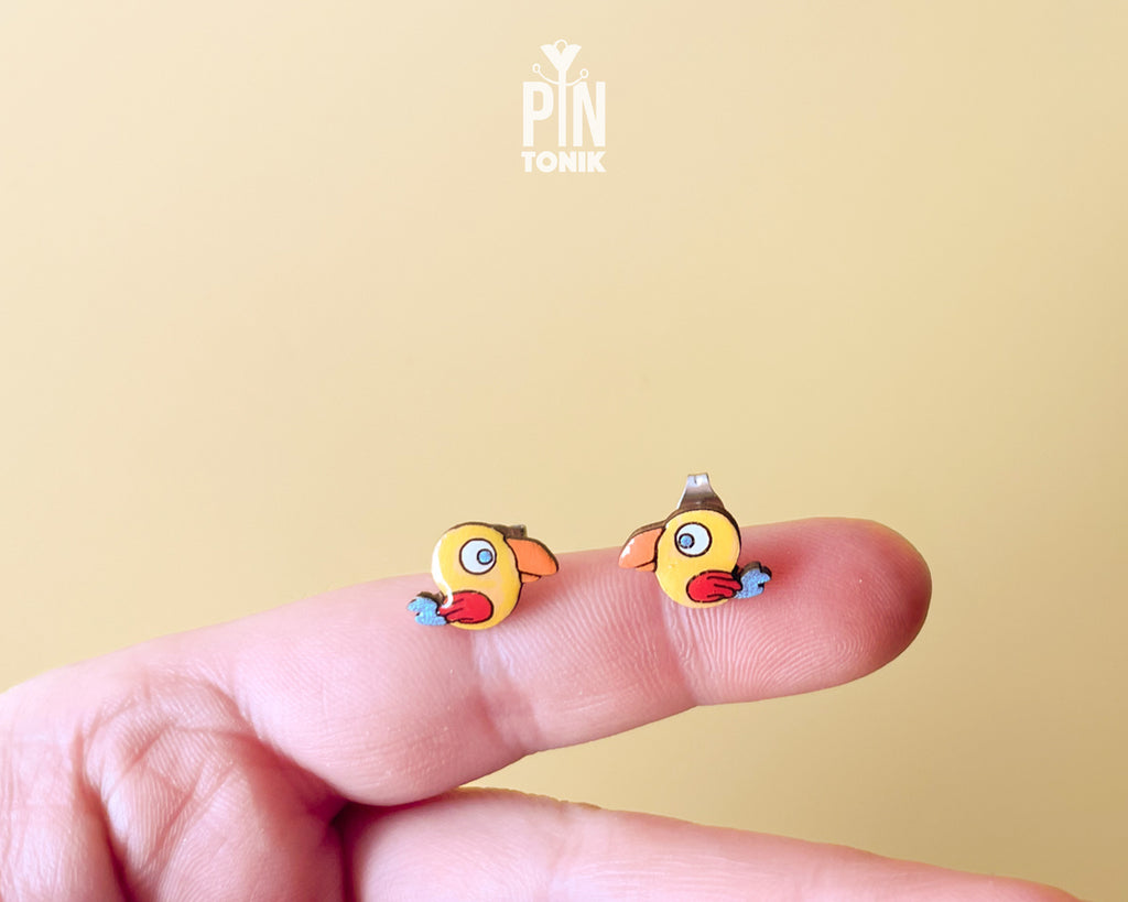 Handmade wooden yellow parrot character stud earrings with a large orange beak by PinTonik, tropical bird themed jewelry.