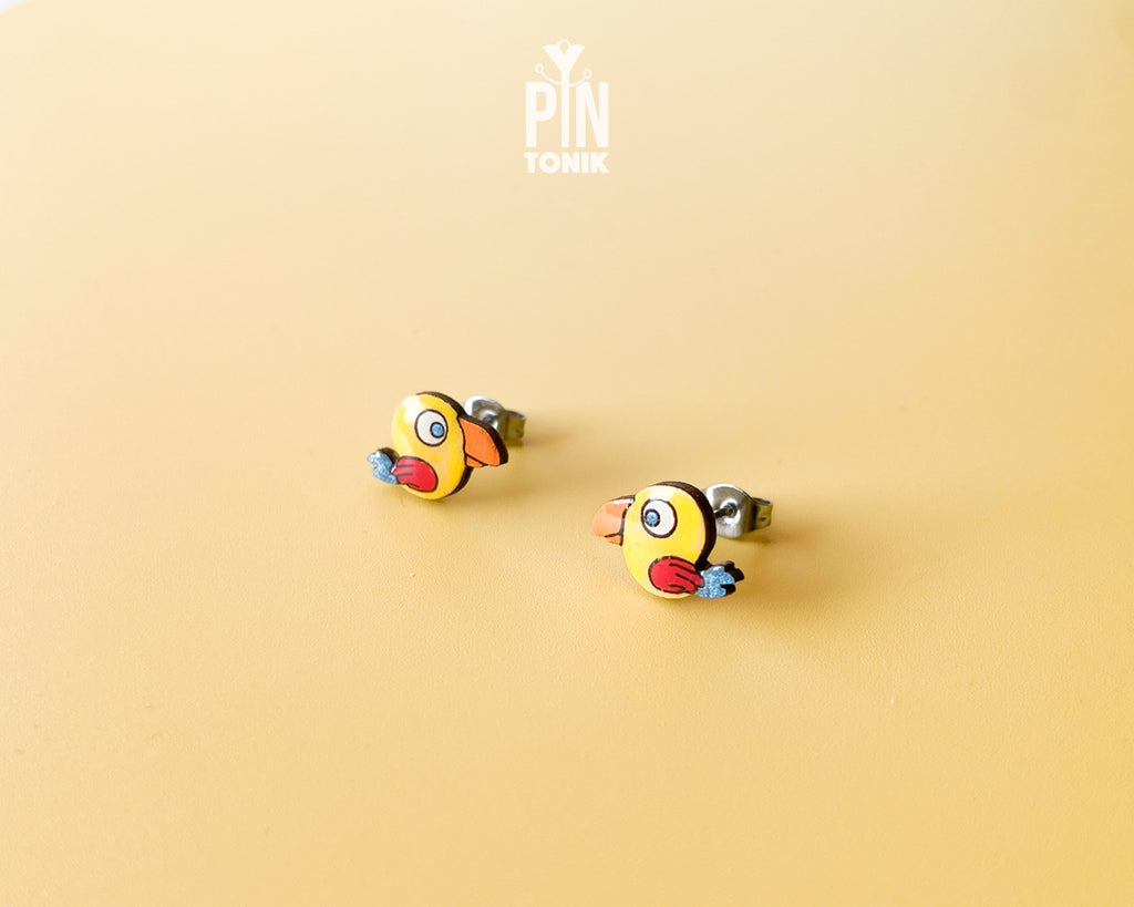 Handmade wooden yellow parrot character stud earrings with a large orange beak by PinTonik, tropical bird themed jewelry.