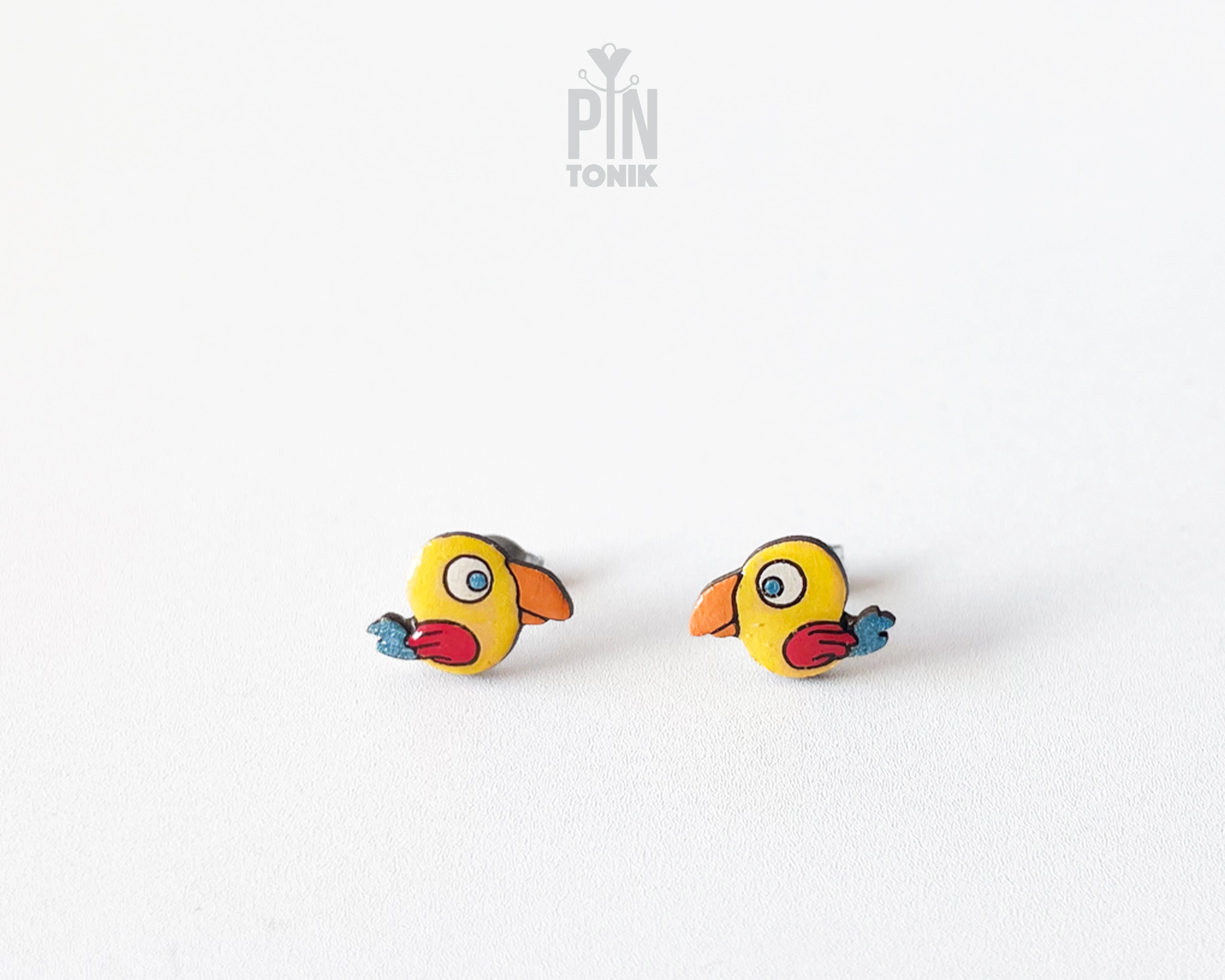 Handmade wooden yellow parrot character stud earrings with a large orange beak by PinTonik, tropical bird themed jewelry.