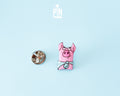 Hand-painted pink wooden pig pin wearing a blue bandana with a high-gloss resin finish