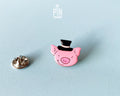 Hand-painted pink wooden pig pin wearing a black top hat with a high-gloss resin finish