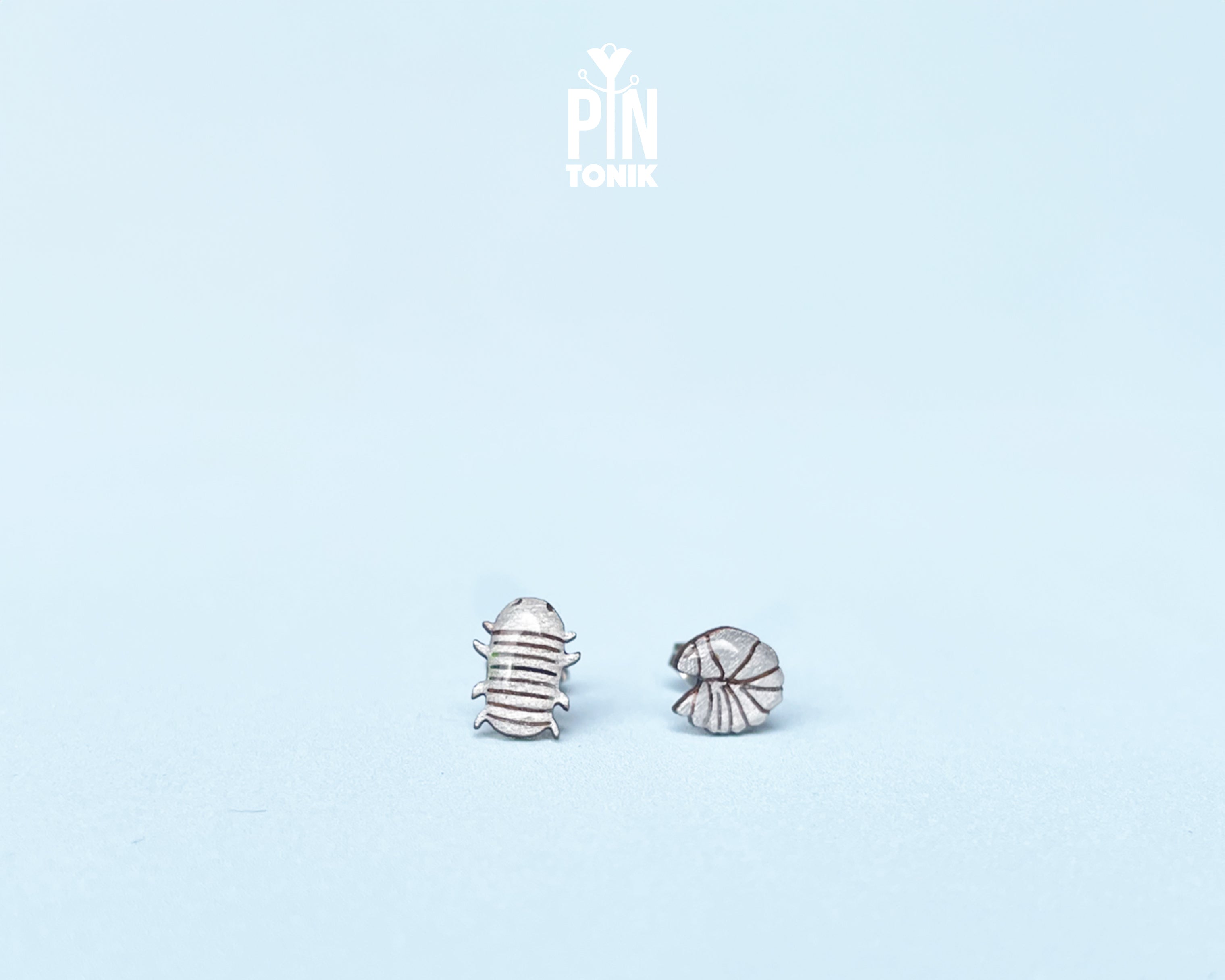 Handmade wooden mismatched rolly polly pill bug stud earrings showing one walking and one curled into a ball by PinTonik.