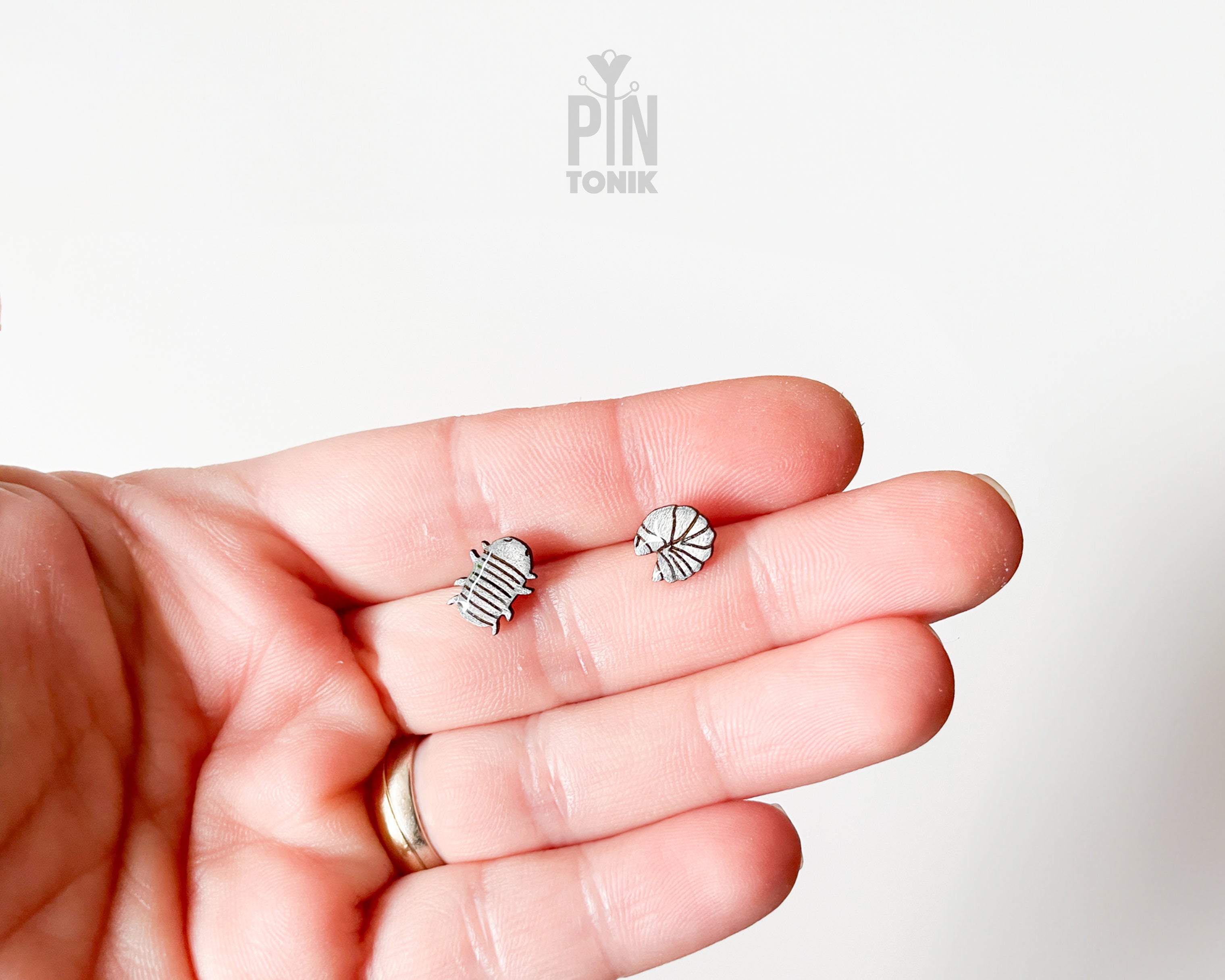 Handmade wooden mismatched rolly polly pill bug stud earrings showing one walking and one curled into a ball by PinTonik.
