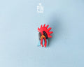 Hand-painted wooden rooster pin with a vibrant red comb and blue neck detail, finished with high-gloss resin