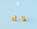Pair of hand-painted yellow wooden duck stud earrings with a high-gloss resin finish