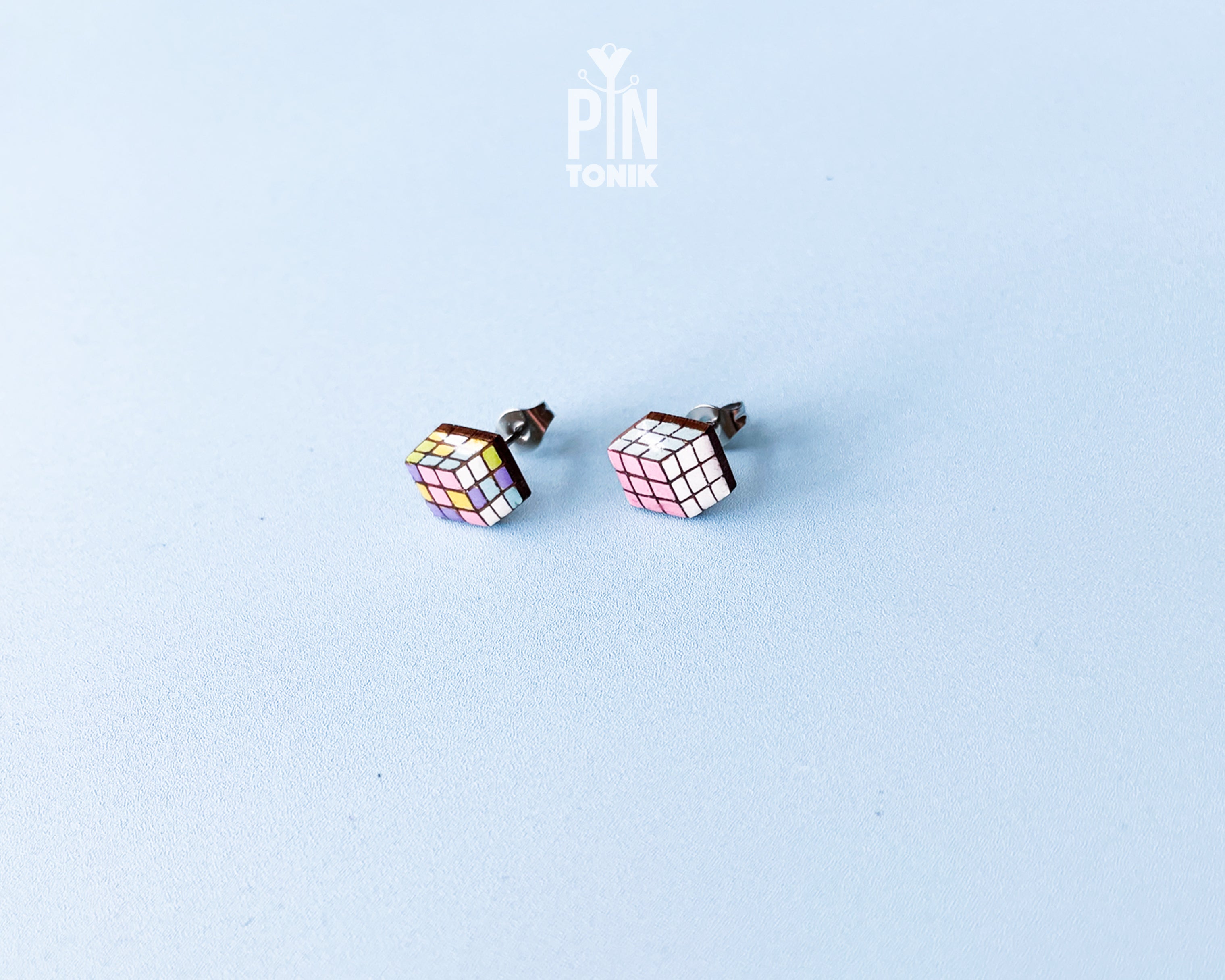 Handmade wooden magic puzzle cube stud earrings showing a three-dimensional perspective with colorful pastel grids by PinTonik