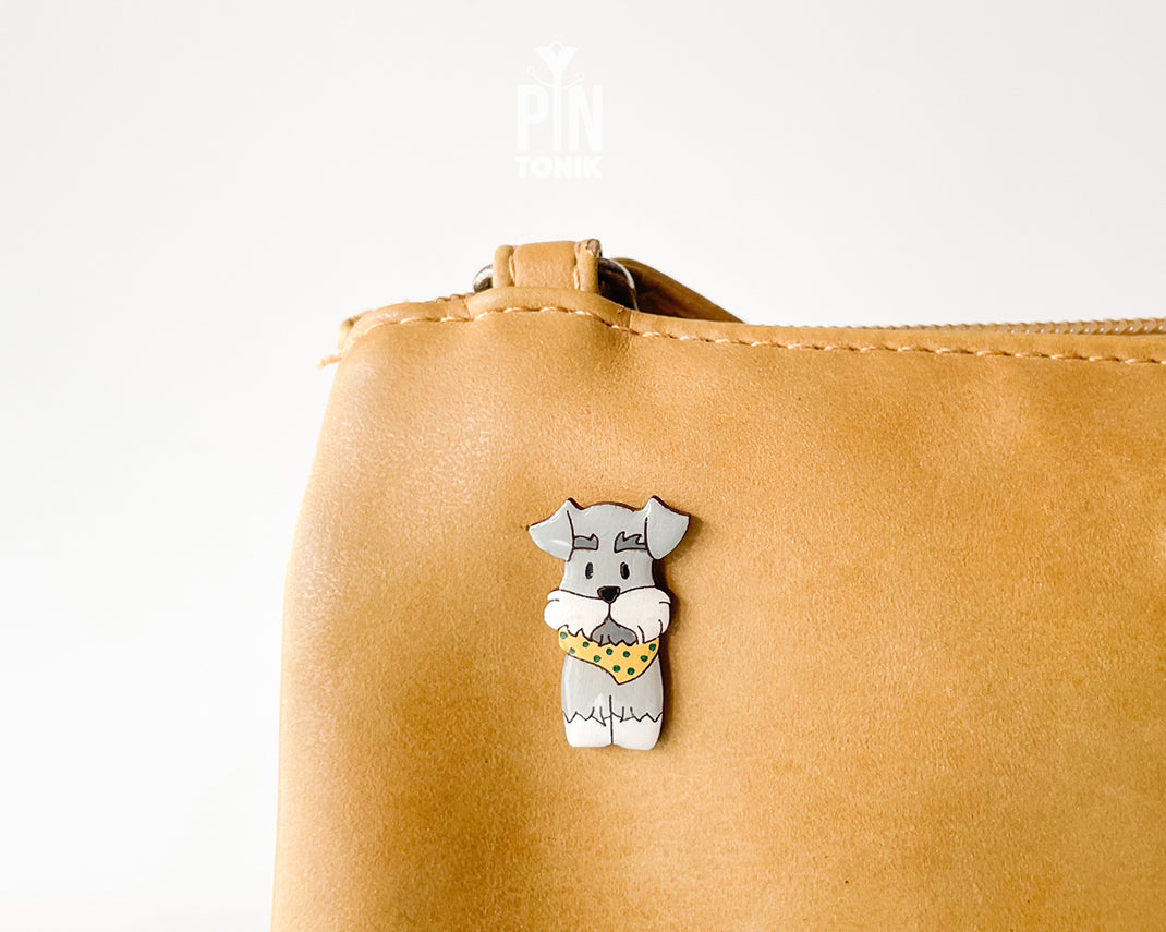 Hand-painted wooden schnauzer dog pin wearing a yellow polka-dot bandana with a glossy resin finish