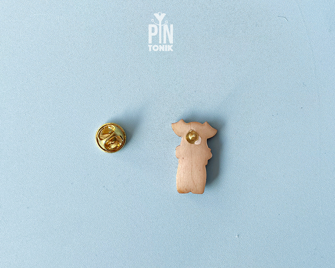 Hand-painted wooden schnauzer dog pin wearing a yellow polka-dot bandana with a glossy resin finish