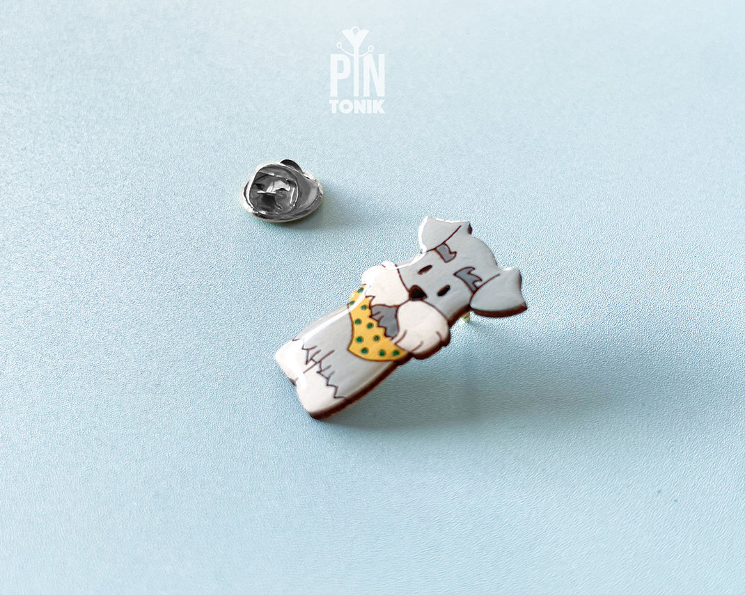 Hand-painted wooden schnauzer dog pin wearing a yellow polka-dot bandana with a glossy resin finish