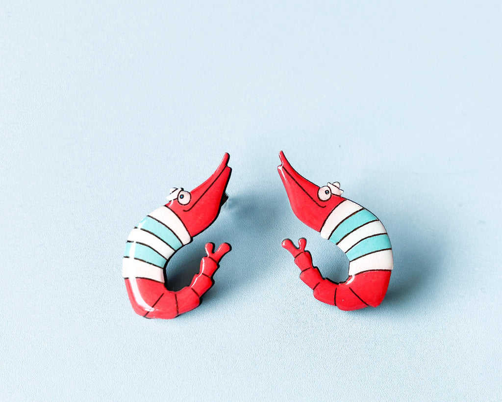 Pair of hand-painted wooden shrimp stud earrings with red and teal stripes and funny wide eyes