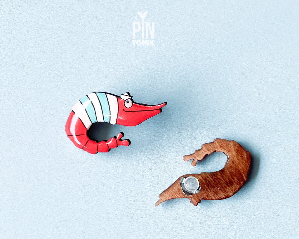 Pair of hand-painted wooden shrimp stud earrings with red and teal stripes and funny wide eyes