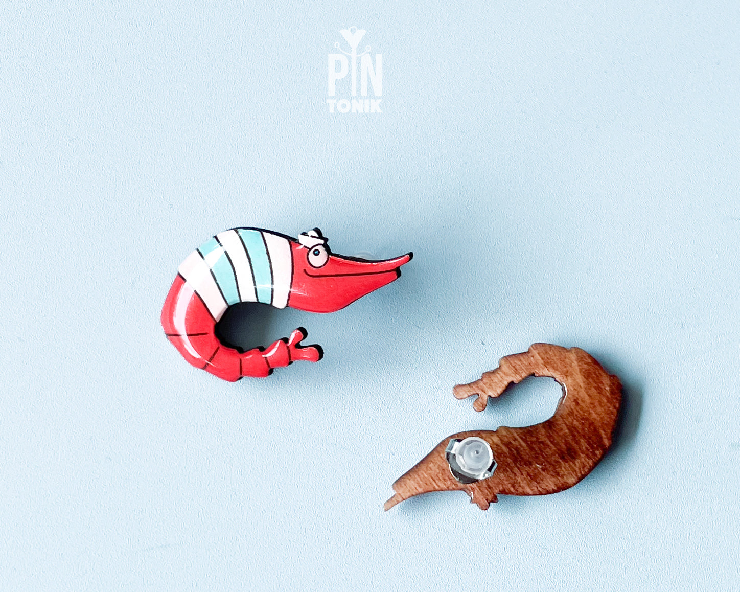 Pair of hand-painted wooden shrimp stud earrings with red and teal stripes and funny wide eyes