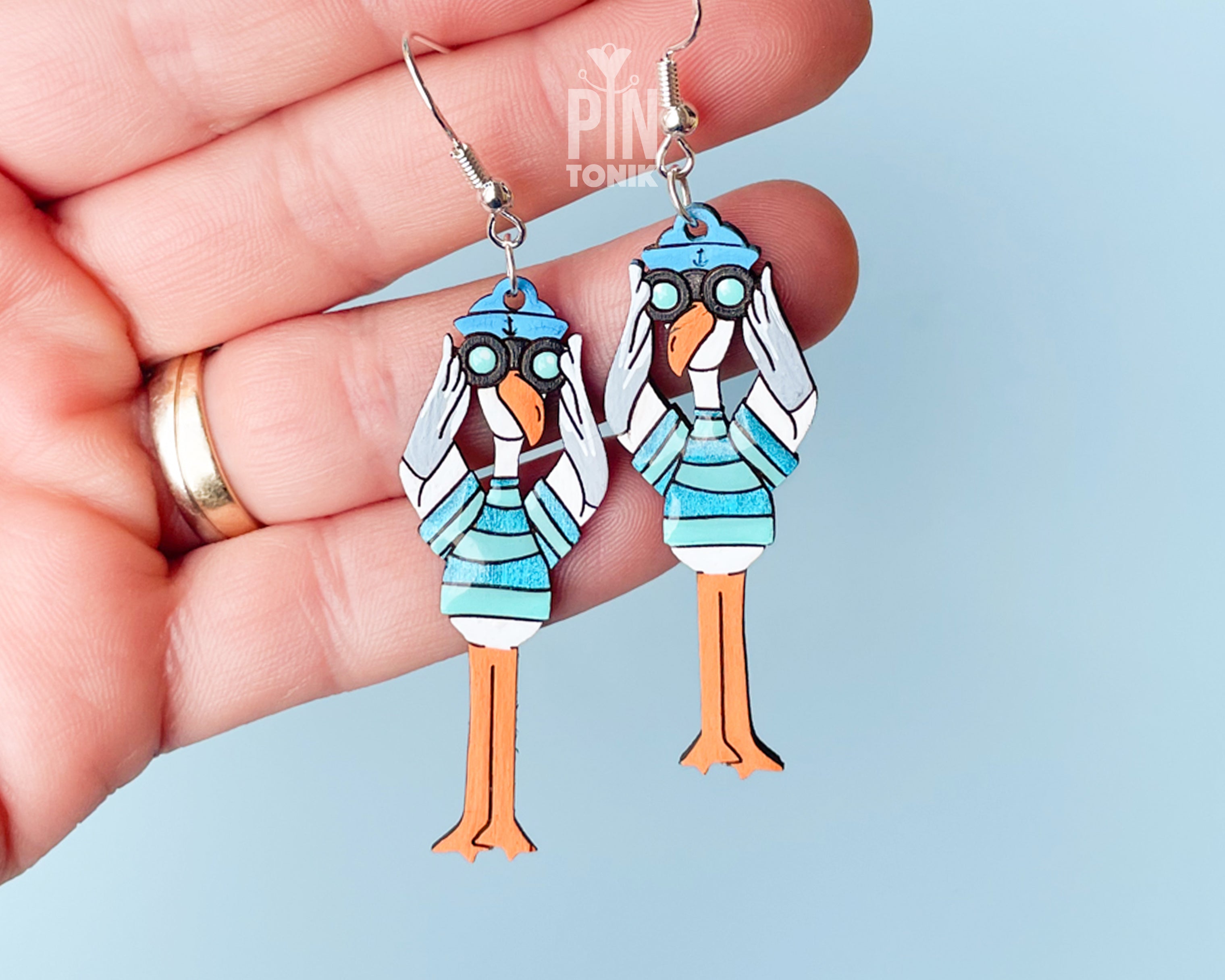 Long hand-painted wooden seagull dangle earrings wearing a teal striped sweater and holding binoculars on sterling silver hooks