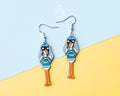 Long hand-painted wooden seagull dangle earrings wearing a teal striped sweater and holding binoculars on sterling silver hooks