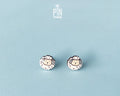 A pair of small stud earrings shaped like cartoon sheep, shown on a light blue background. The sheep have white woolly bodies with black outlines and beige faces.