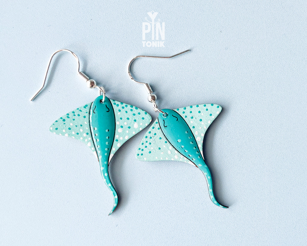 Pair of hand-painted teal wooden stingray dangle earrings with white spots and sterling silver hooks