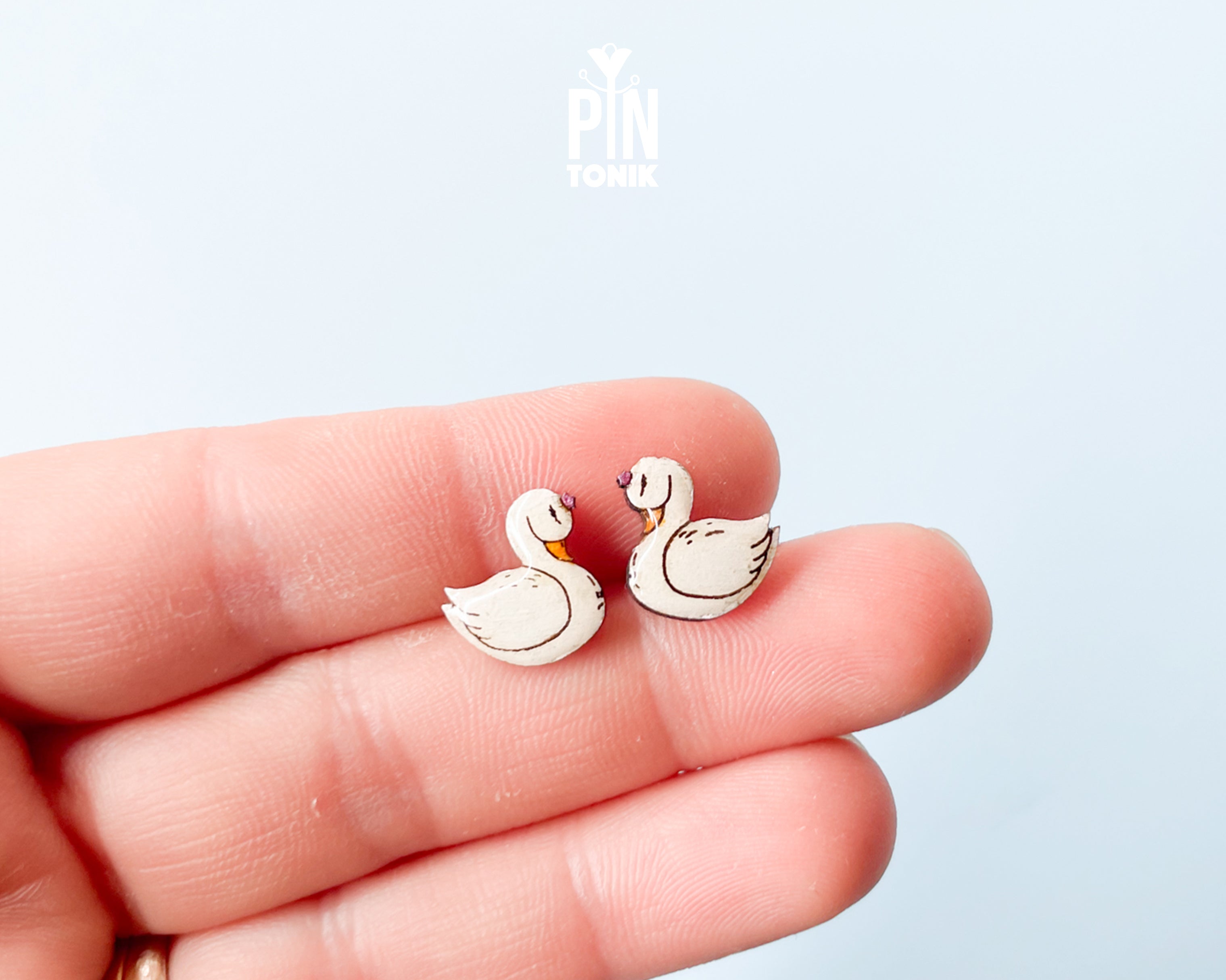 Handmade wooden white swan stud earrings with elegant black and gold detailing by PinTonik, graceful bird themed jewelry.