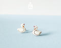 Handmade wooden white swan stud earrings with elegant black and gold detailing by PinTonik, graceful bird themed jewelry.