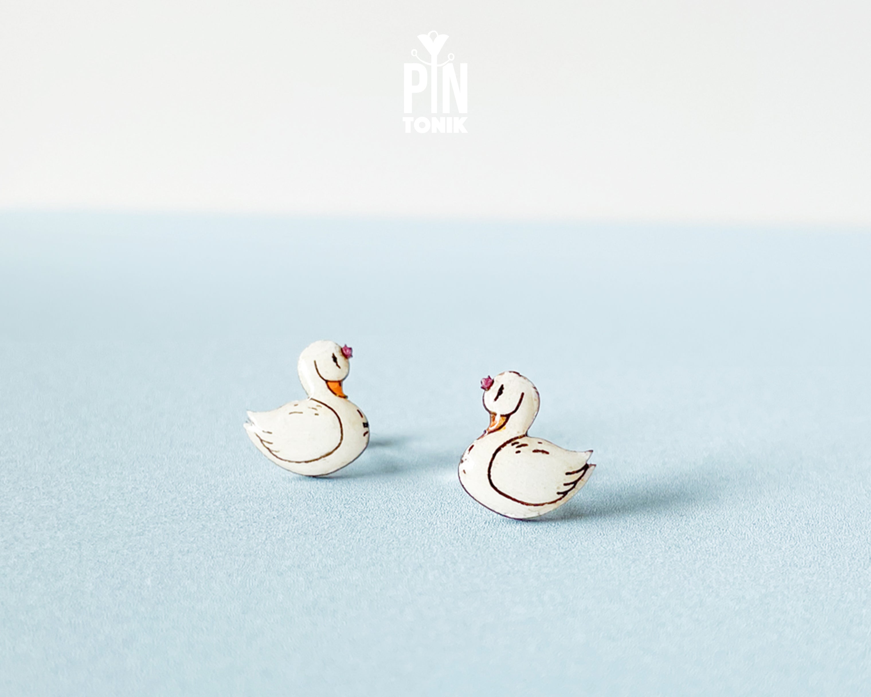 Handmade wooden white swan stud earrings with elegant black and gold detailing by PinTonik, graceful bird themed jewelry.