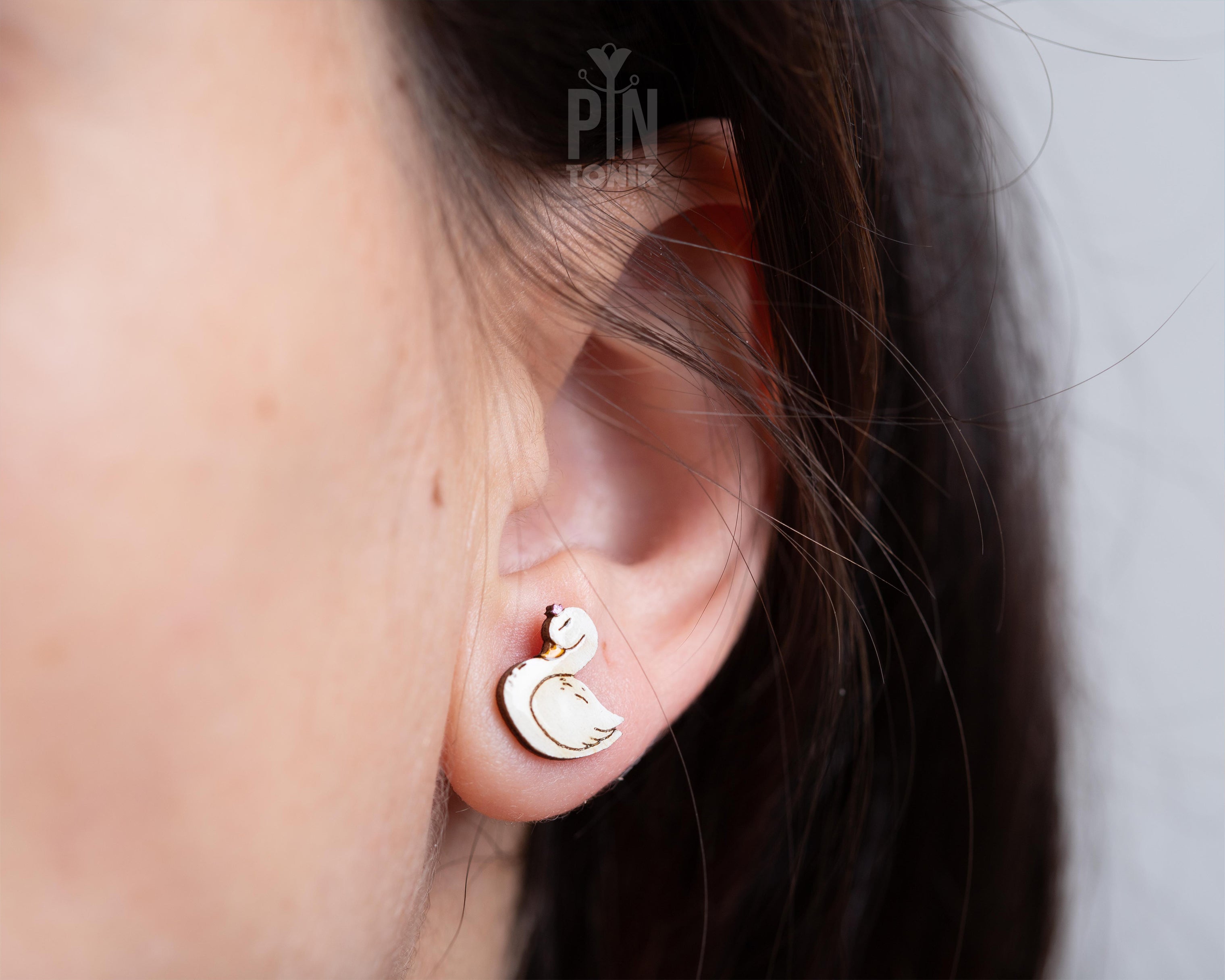 Handmade wooden white swan stud earrings with elegant black and gold detailing by PinTonik, graceful bird themed jewelry.