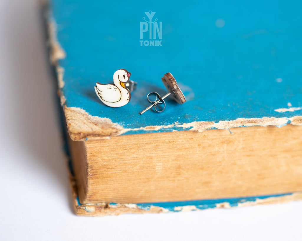 Handmade wooden white swan stud earrings with elegant black and gold detailing by PinTonik, graceful bird themed jewelry.